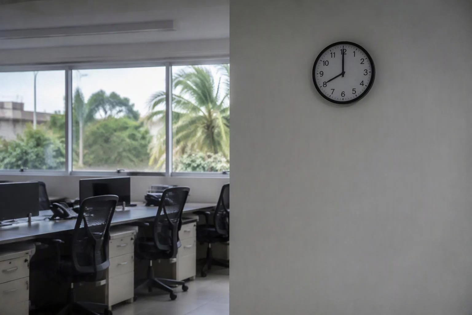 Relógio de parede marcando o começo do turno em sala vazia